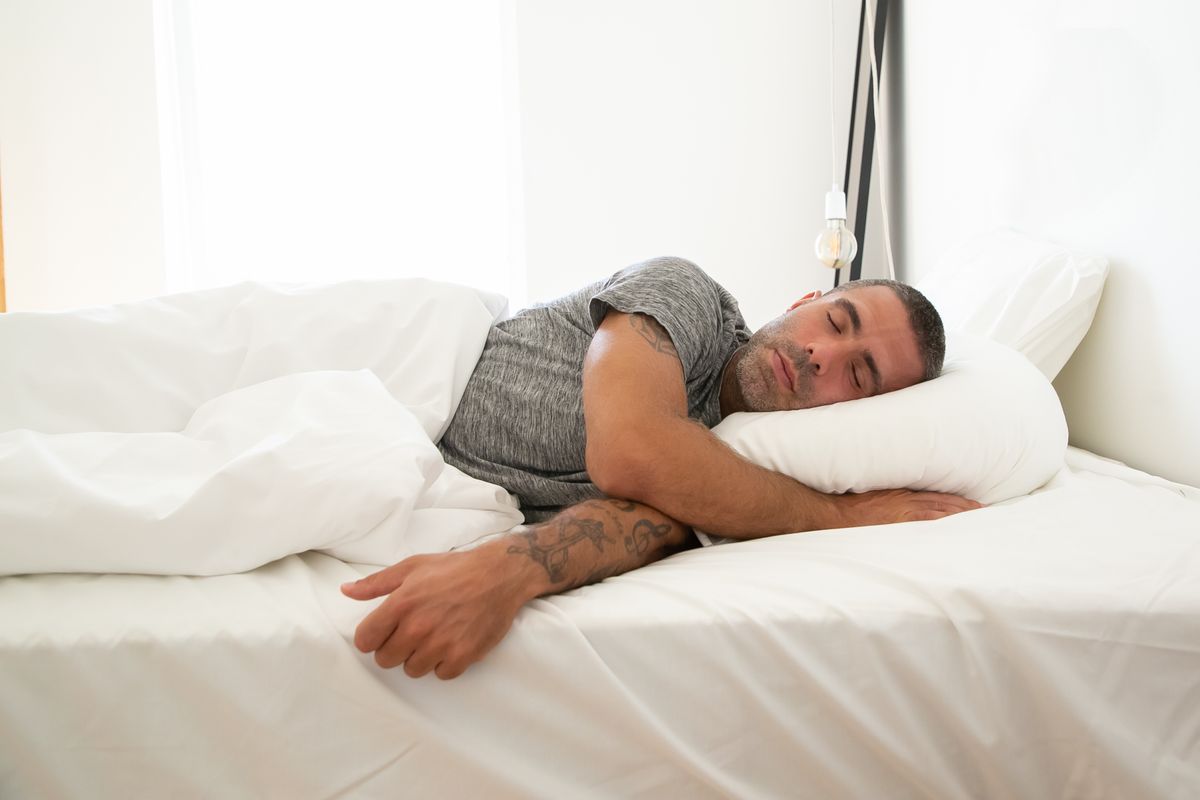 Man sleeping in a bright bedroom